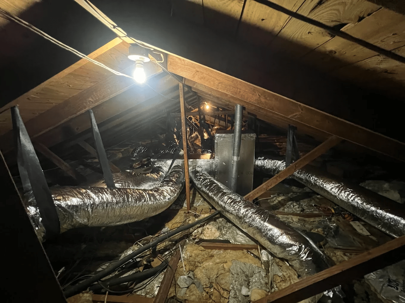 Ductwork and a work light running through a home attic