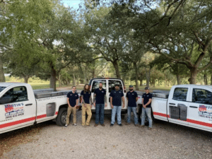 Martin's crew standing between two company trucks